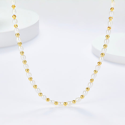 Full view of the Bare Luxe Golden Pearl Necklace laid out on a white surface.