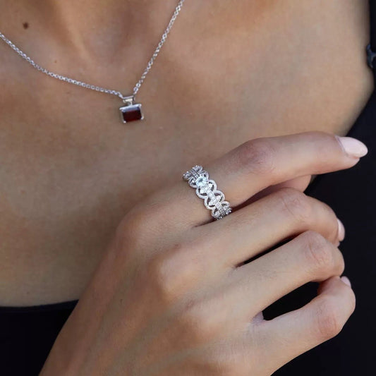 Florentine Lace Ring by Awakened Time worn on a woman's hand, featuring a natural blue topaz gemstone and intricate white gold vermeil lacework design