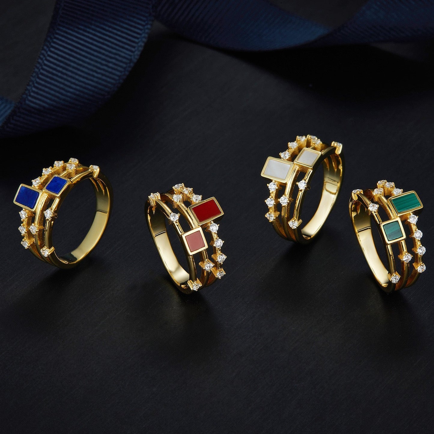 Awakened Time gemstone rings group display featuring malachite, mother of pearl, lapis lazuli, and red stone.