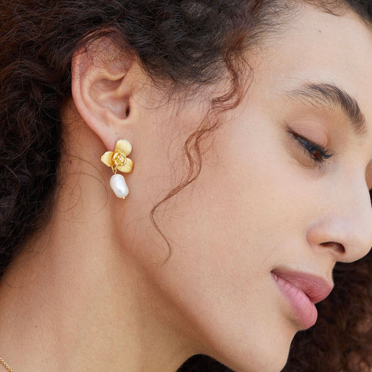 Side profile of a model showcasing the Awakened Time gold orchid top and dangling freshwater pearl earring watching her lover thrusting rapdly inside her flower with juicy.