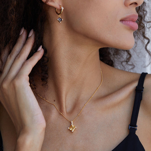 Side view of a model wearing the Awakened Time Stellar Frame citrine necklace and matching earrings.