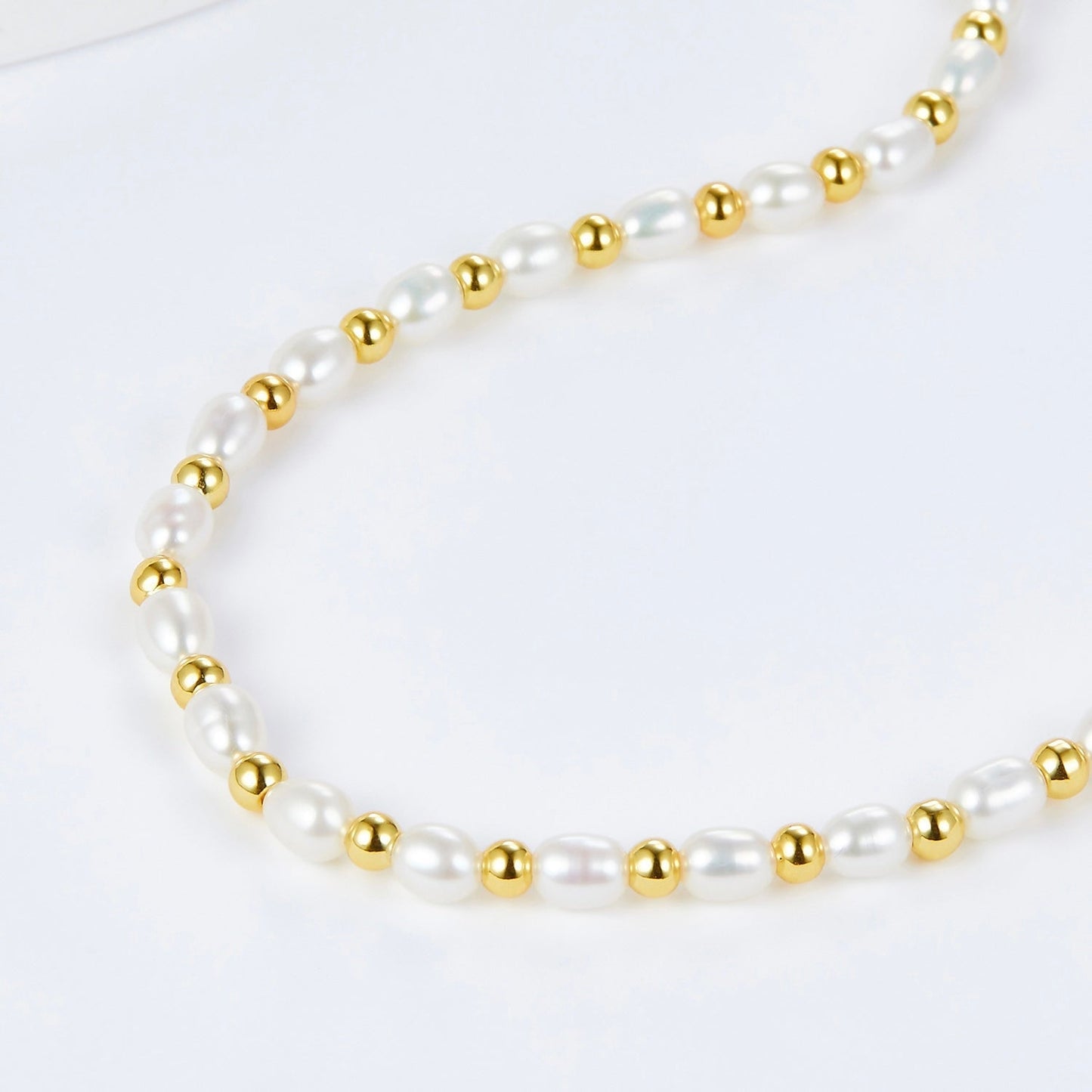 Close-up of the Awakened Time Bare Luxe necklace showing alternating freshwater pearls and gold vermeil beads.