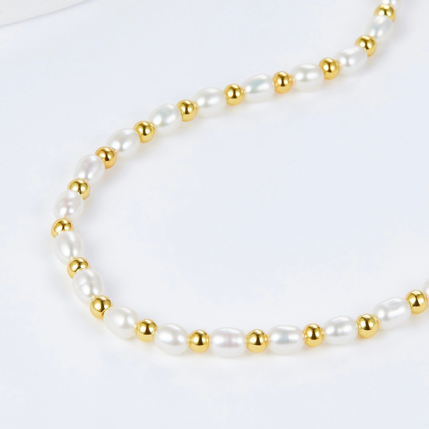 Close-up of the Awakened Time Bare Luxe necklace showing alternating freshwater pearls and gold vermeil beads.