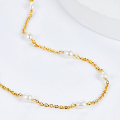 Macro view showing the fine 18ct gold vermeil chain links and luminous freshwater station pearls of the Bare Luxe Orbit necklace.