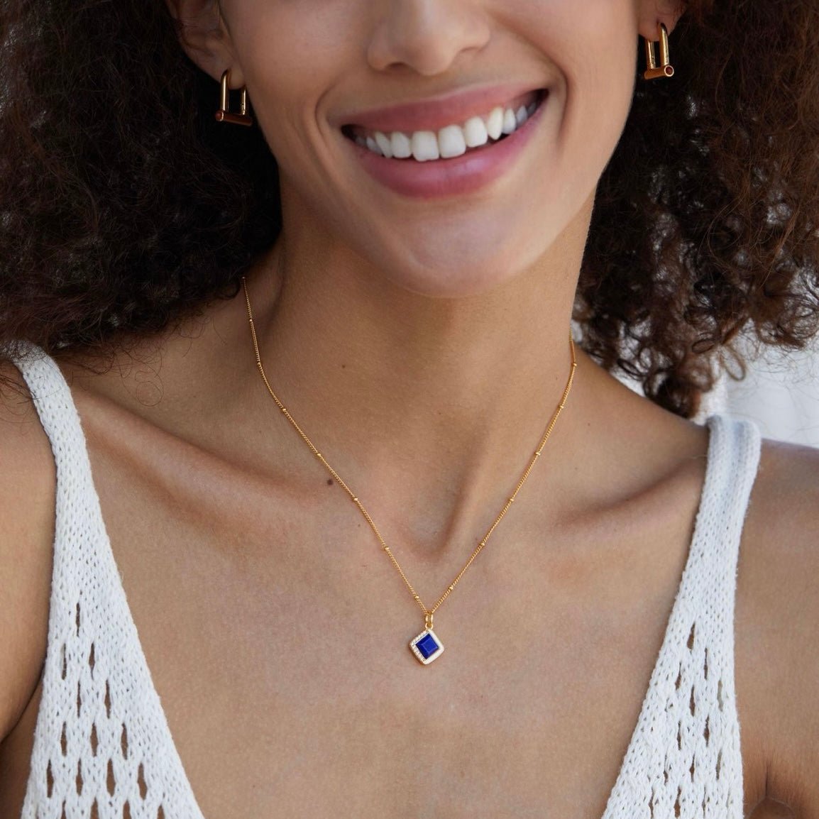 Portrait of a smiling model showcasing the Awakened Time Bleu Intuition gold and deep blue lapis lazuli necklace.