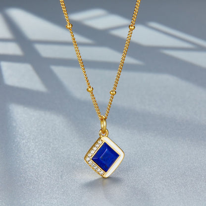 Angle view of the Awakened Time Bleu Intuition lapis lazuli pendant hanging on its gold chain.