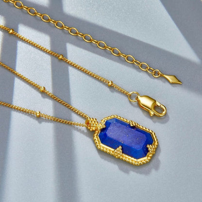 Flat layout showing the gold beaded satellite chain, lobster clasp, extension chain, and lapis lazuli pendant for the Bleu Nuit necklace by Awakened Time.
