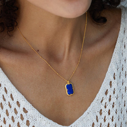 Close-up profile of a model showcasing the Awakened Time Bleu Nuit gold and lapis lazuli pendant.