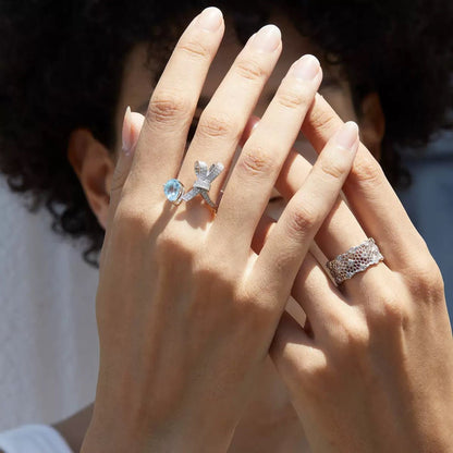Woman wearing the Awakened Time Bleu Ruban Ring with natural blue topaz and cubic zirconia accents in 18ct white gold vermeil.