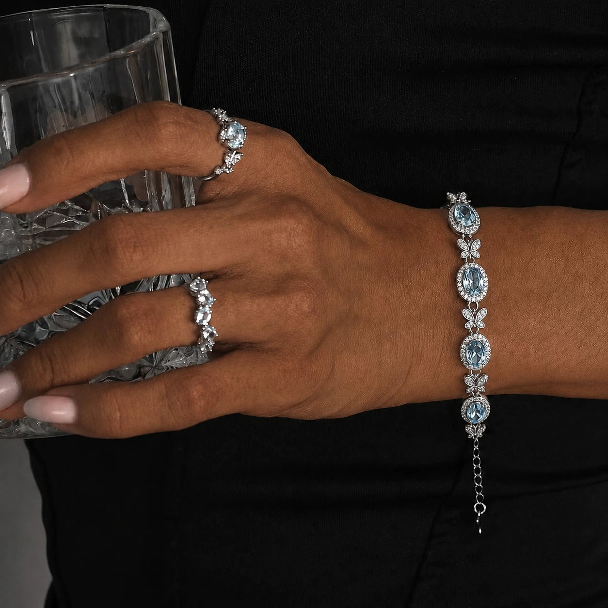 Close-up of the Awakened Time Bluelace Bracelet in S925 sterling silver with four natural blue topaz gemstones and butterfly-inspired details worn on the wrist.