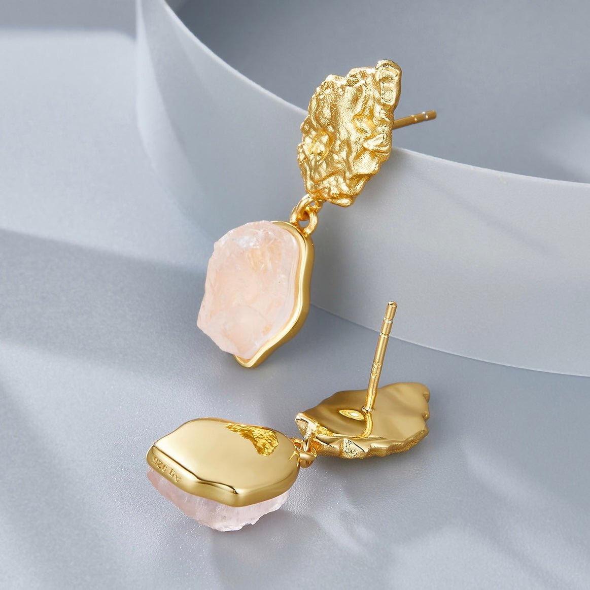 Detailed view of Awakened Time gold vermeil rose quartz earrings showing post backings and smooth back plates.