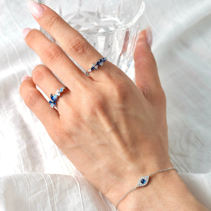 Close-up of a woman wearing the Awakened Time Evil Eye Bracelet with a blue gemstone charm, delicate silver chain, and symbolic protection-inspired design.