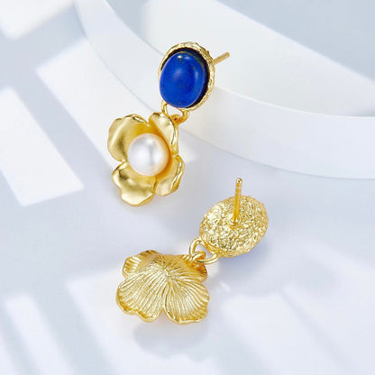 Studio product shot showing front and back detail of Awakened Time Fleur de Lapis gold drop earrings, highlighting textured gold post backs, blue lapis lazuli, and freshwater pearl center.