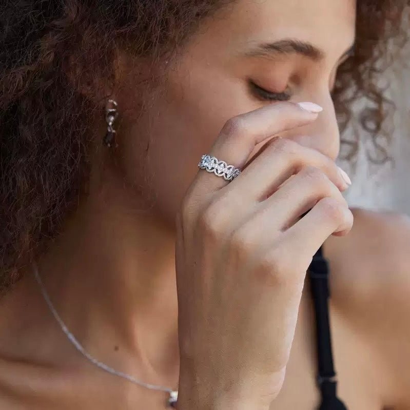 Florentine Lace Ring by Awakened Time worn elegantly by a woman, featuring natural blue topaz gemstone and delicate white gold vermeil lacework design.