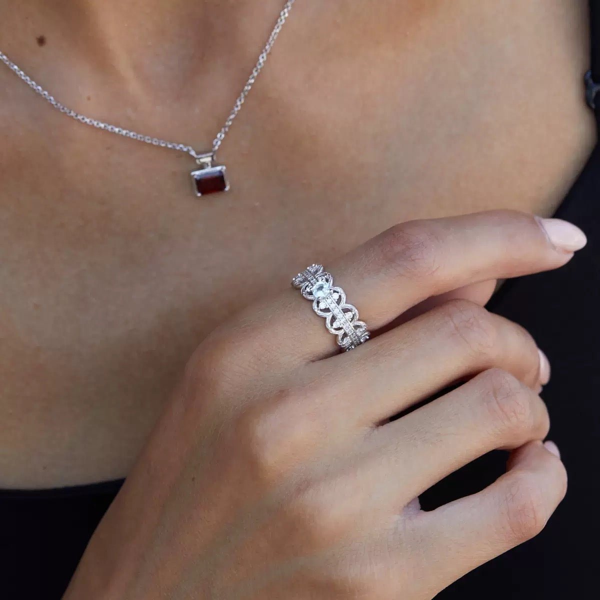 Florentine Lace Ring by Awakened Time worn on a woman's hand, featuring a natural blue topaz gemstone and intricate white gold vermeil lacework design