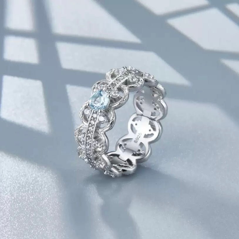 Florentine Lace Ring by Awakened Time showcasing natural blue topaz, intricate openwork silver lace design, and sparkling pavé details.