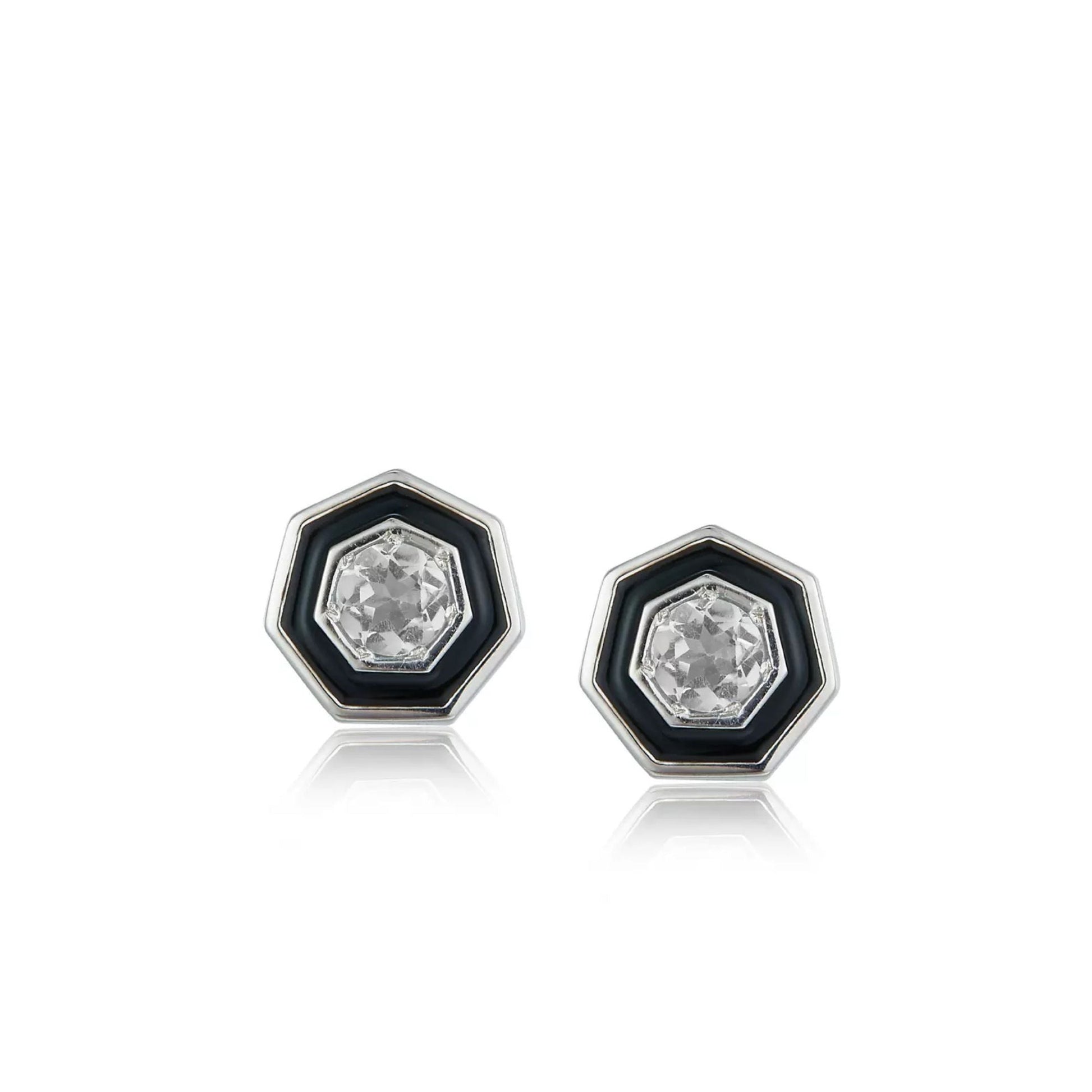 Pair of Awakened Time hexagonal stud earrings featuring clear faceted crystal centers enclosed by black enamel halos and silver borders on a white background.