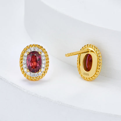 Studio view of the Awakened Time Imperial Romance gold vermeil studs showing the oval garnet, diamond-pave border, and earring post.