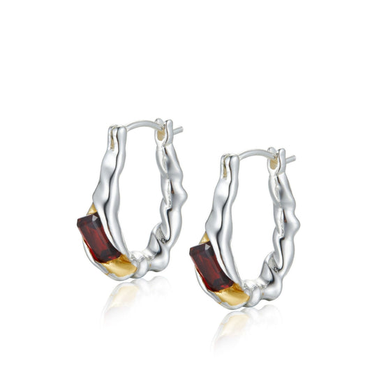 Pair of Awakened Time Lava Ember hoop earrings featuring organic molten silver textures cradling baguette-cut red garnet gemstones with gold accents on a white background.