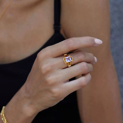 Close-up of a model's hand wearing The Lilac Crown Ring with a radiant lilac amethyst by Awakened Time.