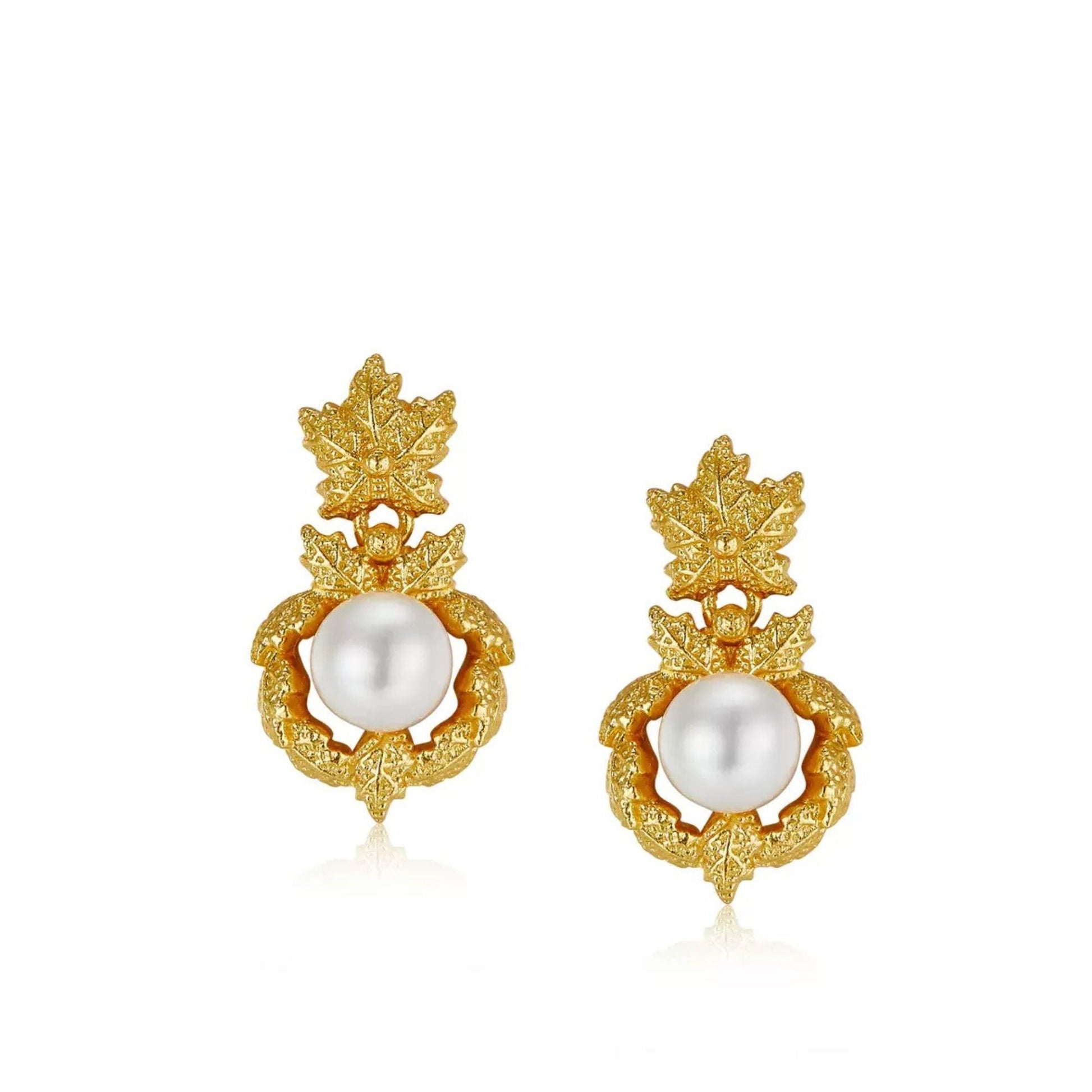 Pair of Awakened Time L’Or de l’Automne drop earrings featuring textured gold maple leaf studs suspending white pearls framed in sculpted gold leaf wreaths on a white background.