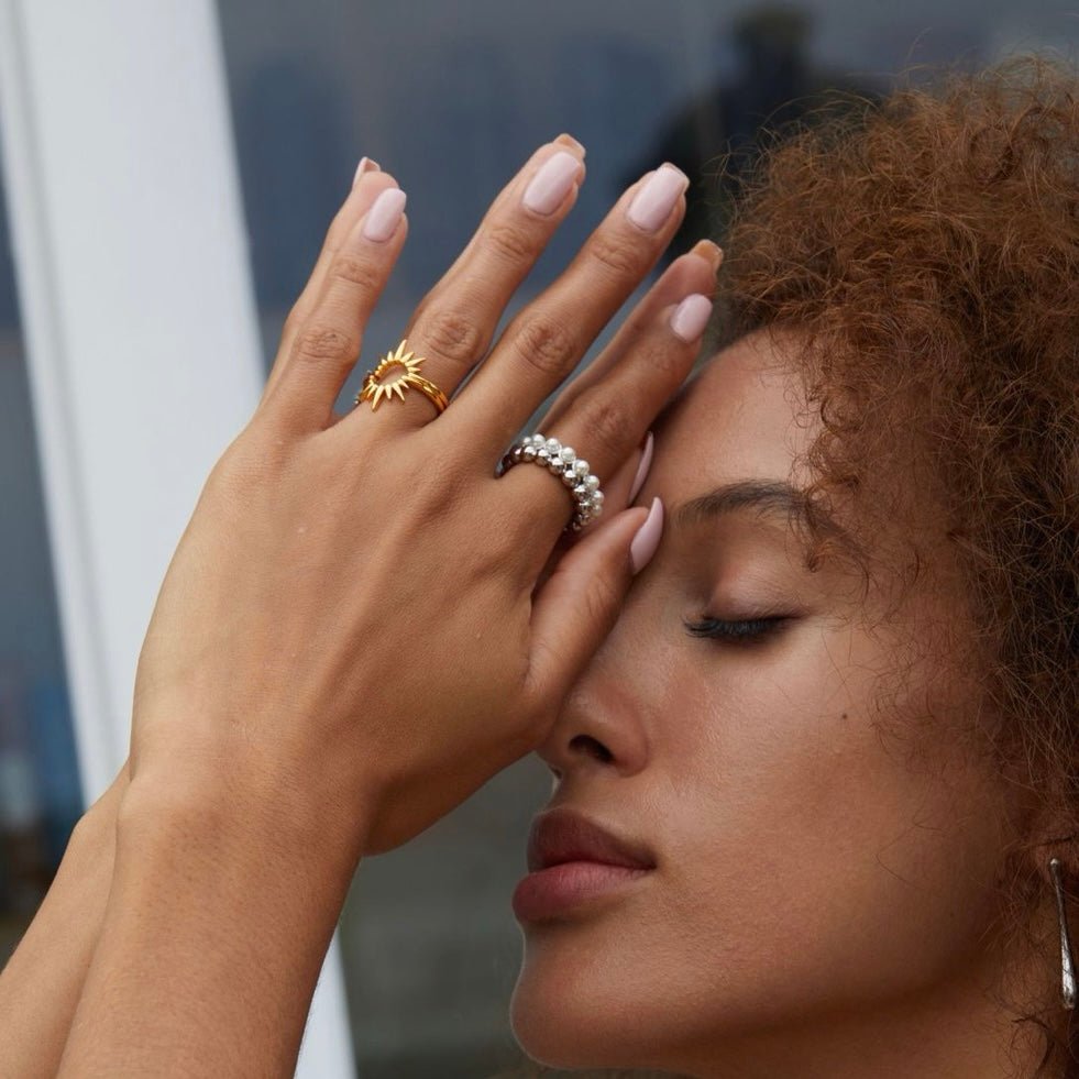 Macro portrait of a model wearing The Lumière white gold-plated pearl ring by Awakened Time.