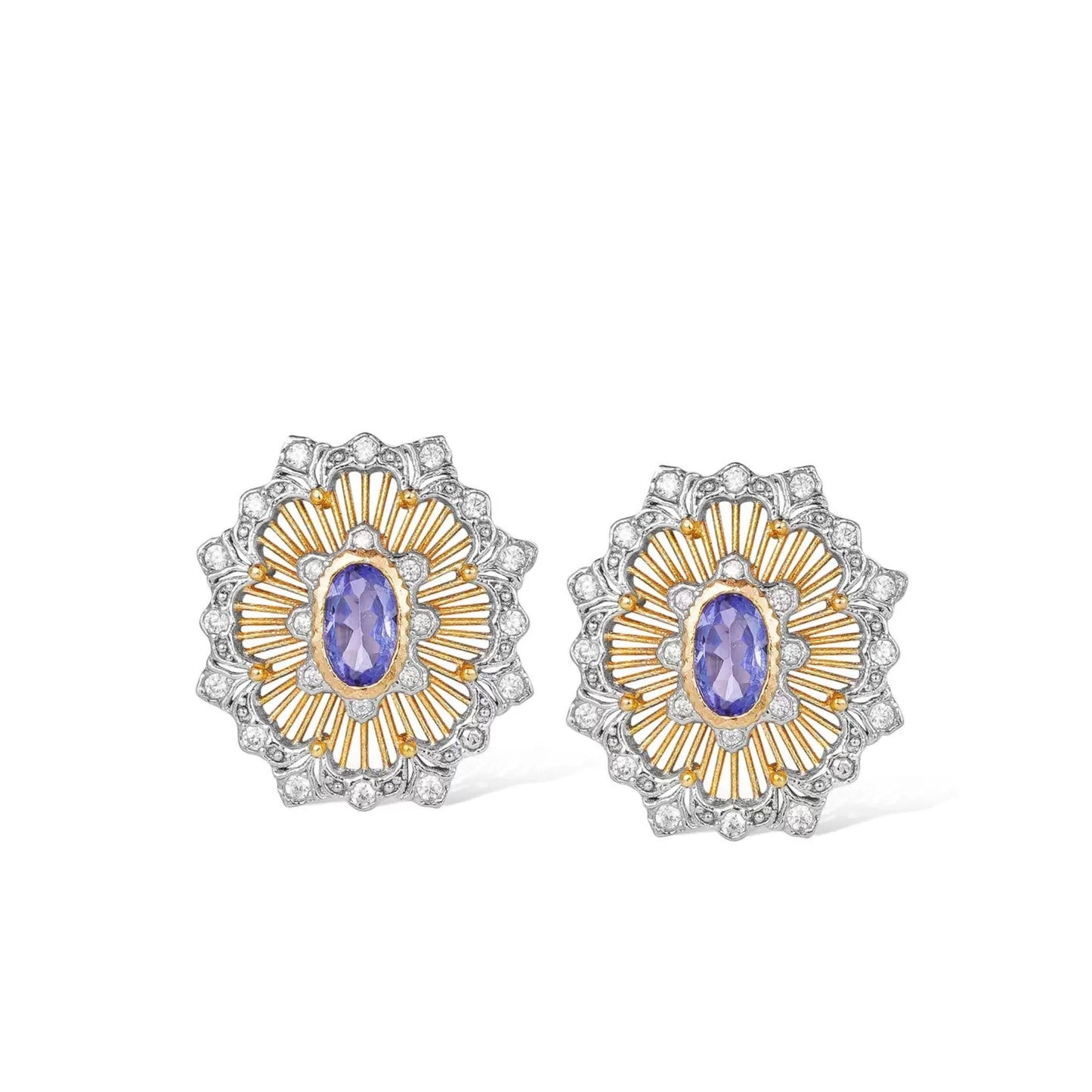 Pair of Awakened Time Medici’s Bloom two-tone stud earrings featuring oval natural tanzanite centers framed by gold sunburst rays and silver pavé zirconia scalloped borders on a white background.