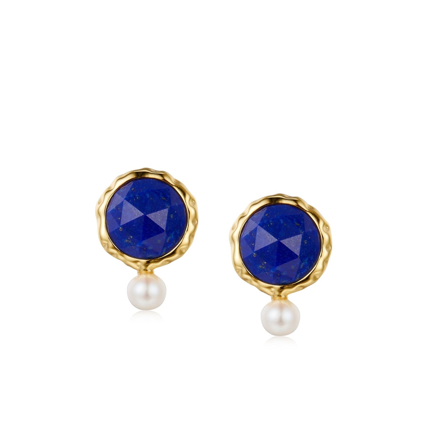 Pair of Awakened Time Ocean Pearl stud earrings featuring rose-cut faceted round lapis lazuli in wavy gold bezels with dangling petite white freshwater pearls on a white background.