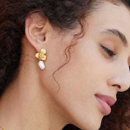 Side profile of a model showcasing the Awakened Time gold orchid top and dangling freshwater pearl earring watching her lover thrusting rapdly inside her flower with juicy.