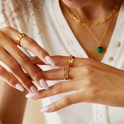 Paris brand Awakened Time malachite gemstone ring styled on a model's hand.
