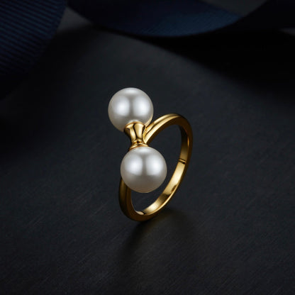 The Petite Symétrie pearl ring styled on a dark reflective background, highlighting its 18ct gold vermeil finish by Awakened Time.