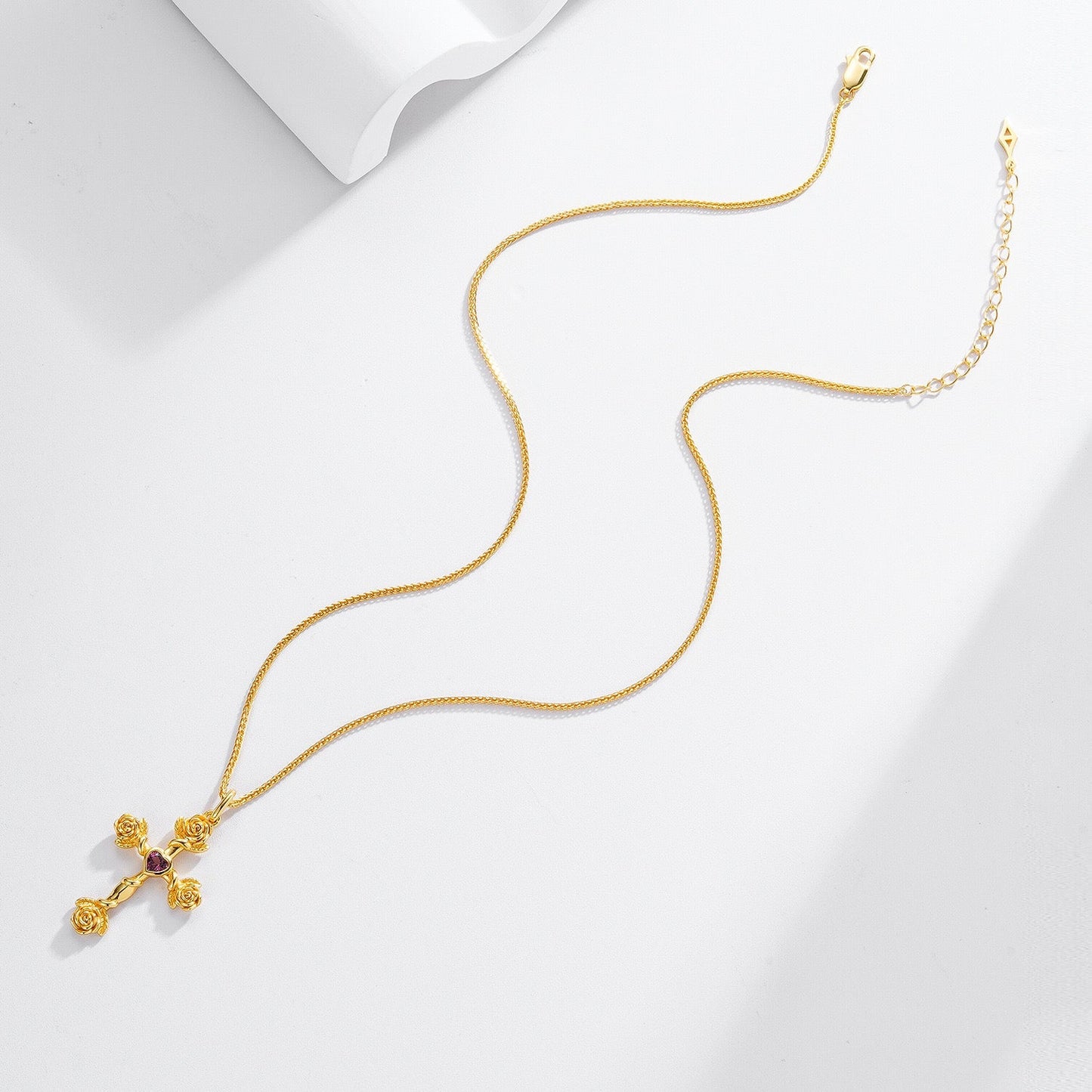 Complete Awakened Time Rosevine Cross Pendant with gold chain laid flat on a light background.