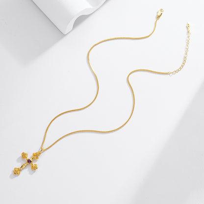 Complete Awakened Time Rosevine Cross Pendant with gold chain laid flat on a light background.