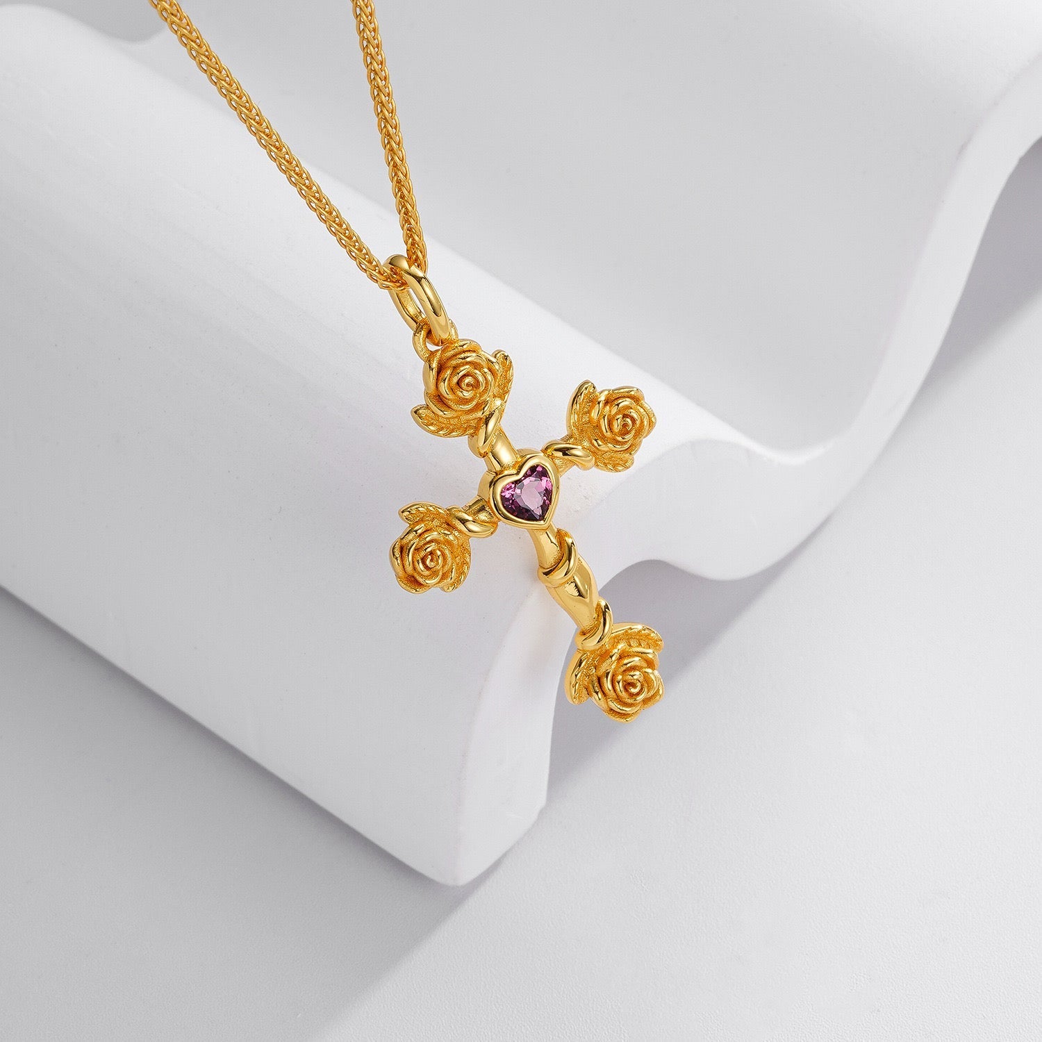 Close-up angled view of the Awakened Time Rosevine Cross Pendant on a white display stand.