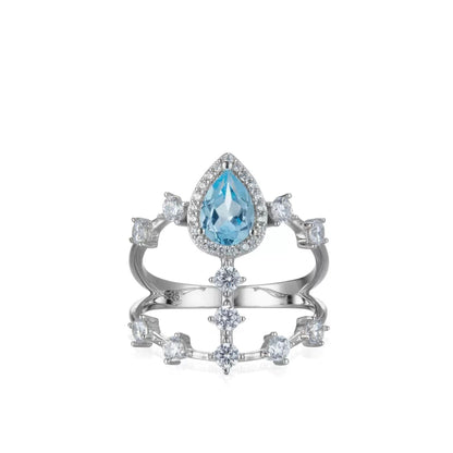 Awakened Time Sky Vault Ring in white gold vermeil featuring a central pear-cut blue topaz surrounded by cubic zirconia in a sculptural openwork setting.