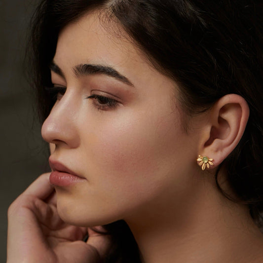 Side profile of a model wearing Awakened Time floral Songe de Marguerite green aventurine gold stud earrings.