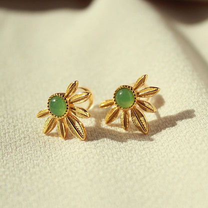 Close-up of Awakened Time green aventurine daisy earrings in 18ct gold vermeil resting on textured cream fabric.