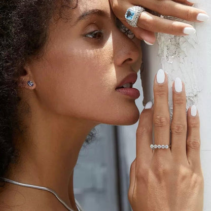 Woman wearing the Awakened Time Timeline Ring featuring five natural blue topaz stones in a delicate bezel-set arc with an 18ct white gold vermeil finish.