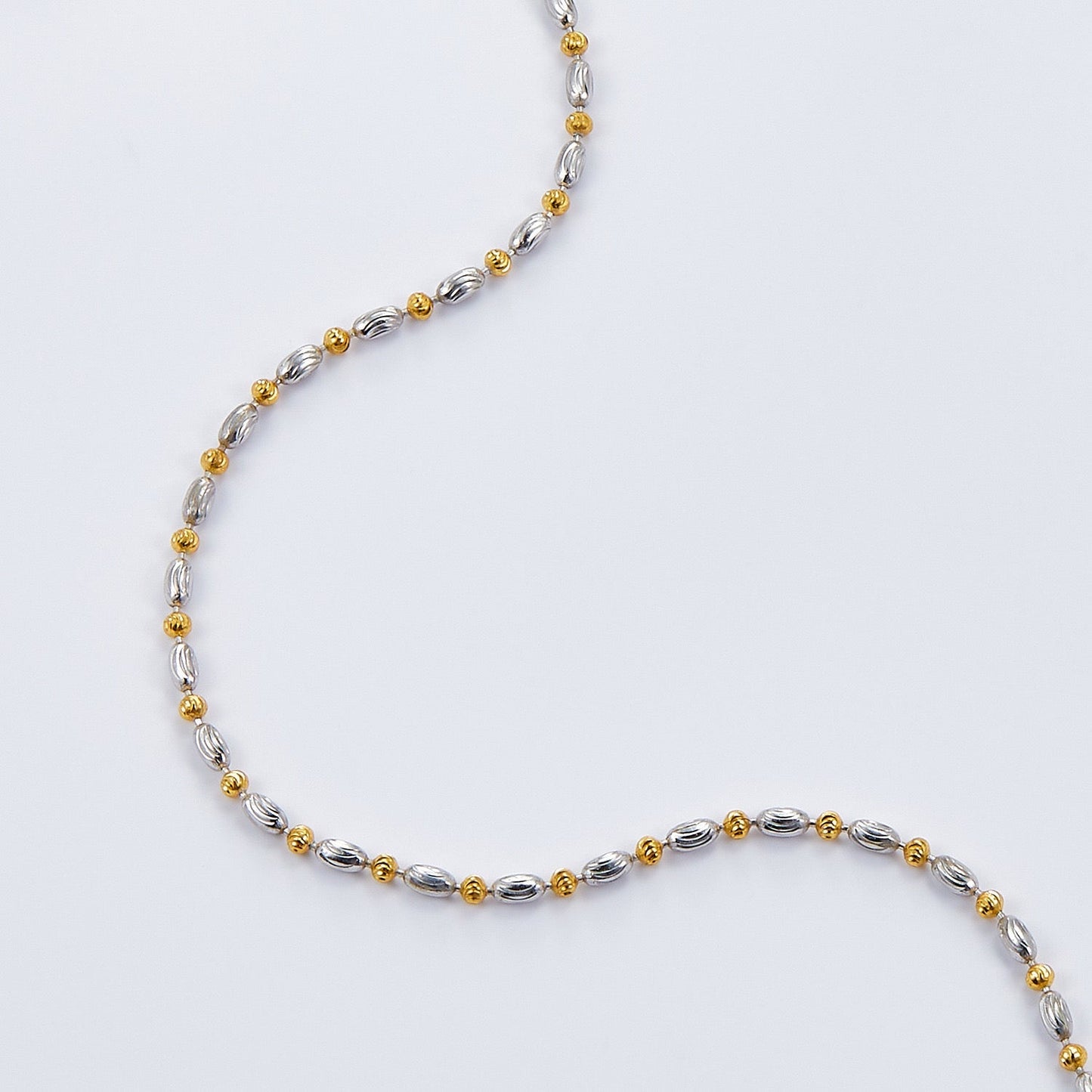 Close-up detail of the light-catching Éclat chain links in gold and white gold vermeil