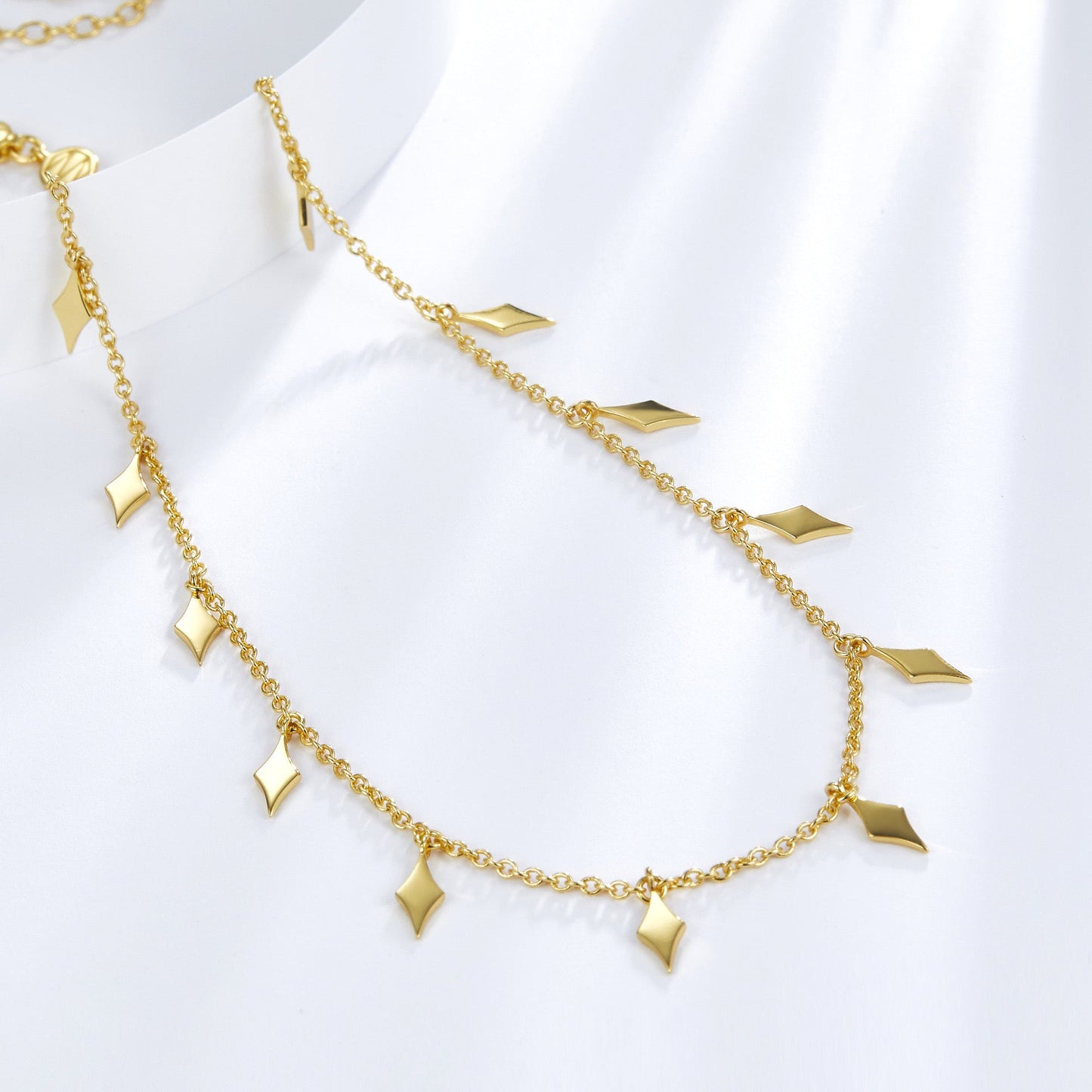 Angled view showing the hanging diamond droplet charms on the Venus Drip gold chain