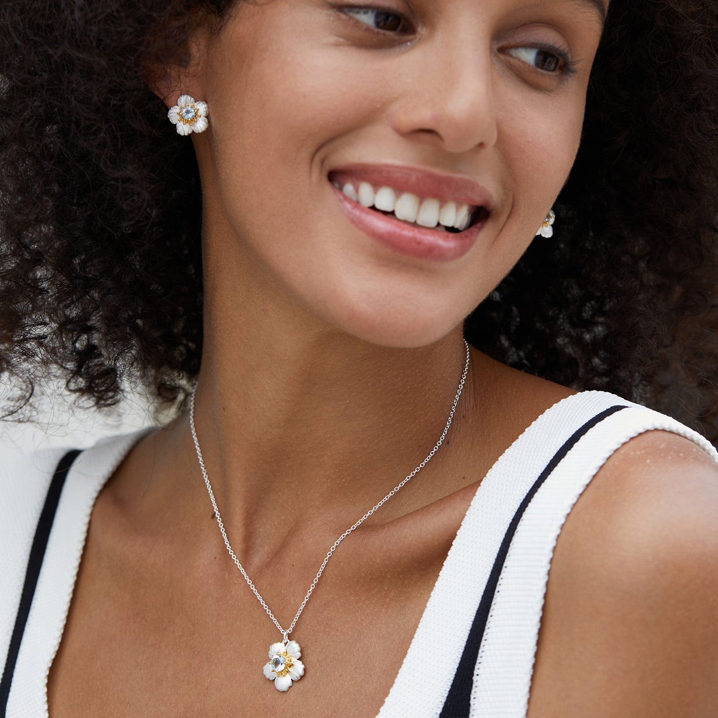 beautiful Model wearing the matching Bleu de Jardin flower stud earrings and blue topaz pendant necklace.