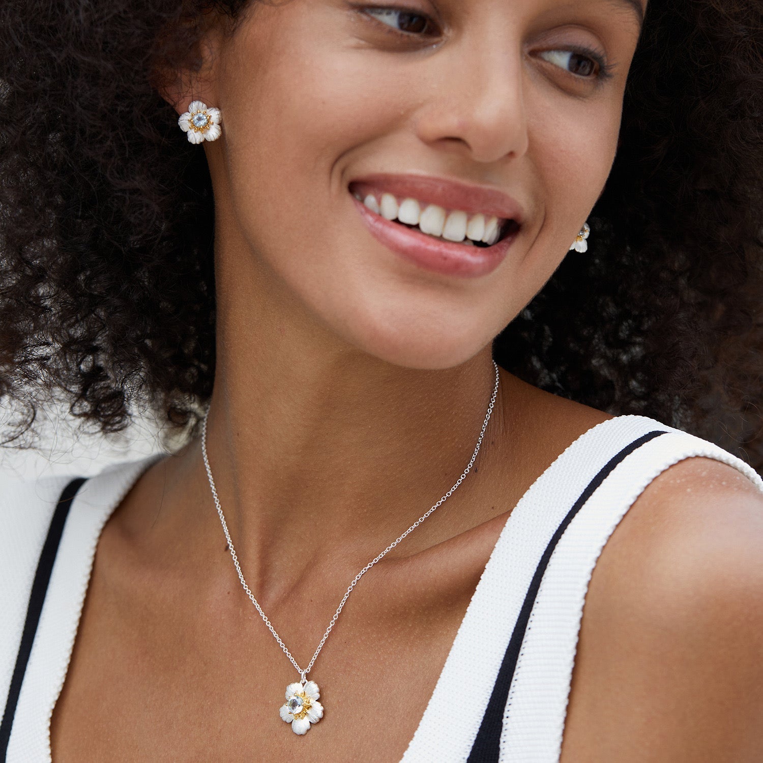 beautiful Model wearing the matching Bleu de Jardin flower stud earrings and blue topaz pendant necklace.