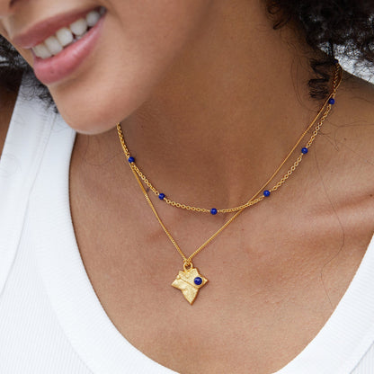 Blue Orbit lapis lazuli necklace layered with a gold pendant necklace