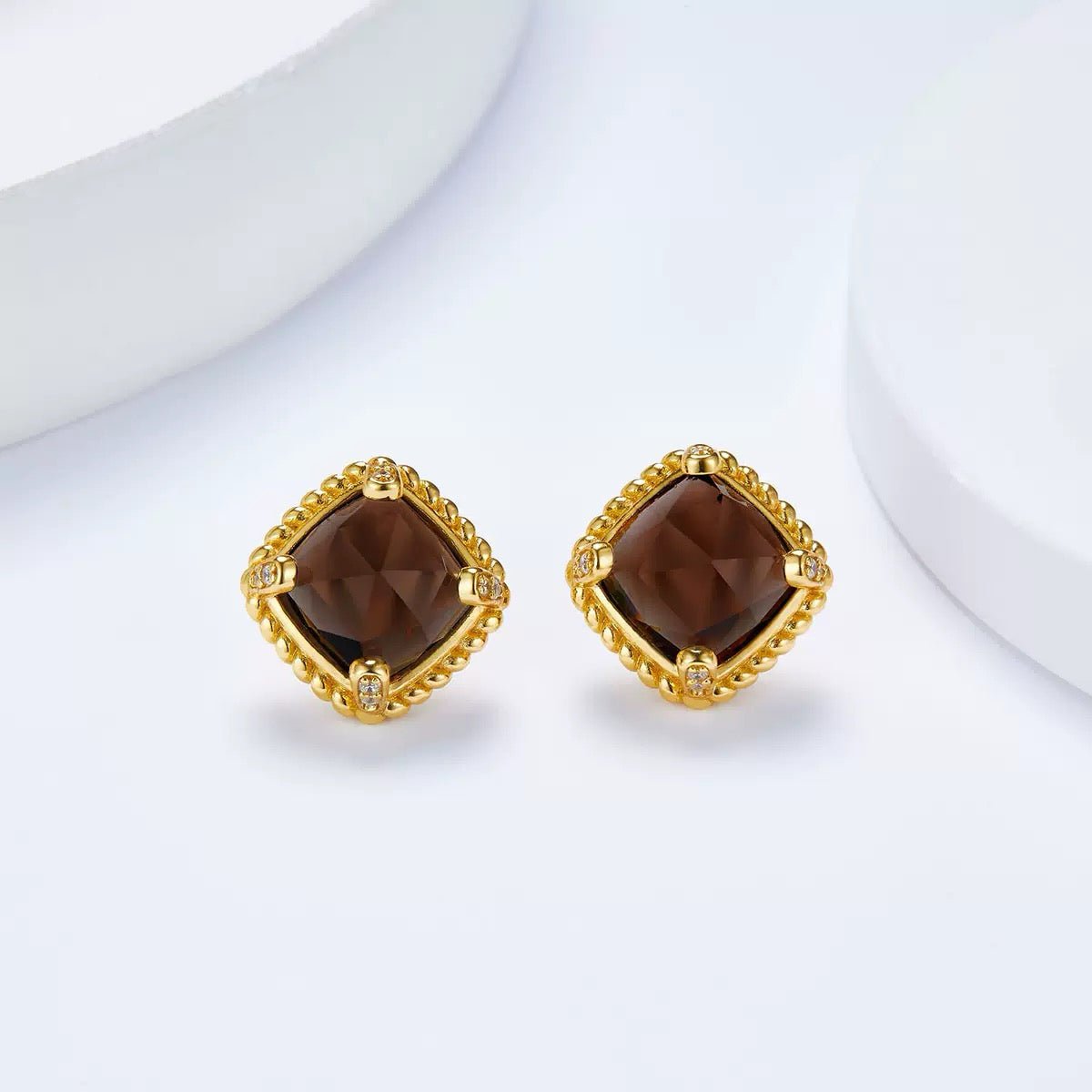 Frontal view of both Cocoa Luxe stud earrings showcasing the faceted cushion-cut smoky quartz and gold beaded frame.
