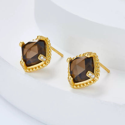 Angled view of Cocoa Luxe stud earrings displaying the cushion-cut smoky quartz gem and gold earring post.