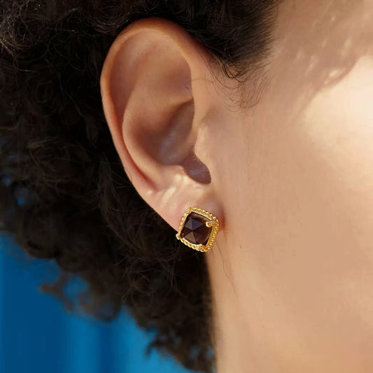 Close-up profile of a model wearing the square-cut Cocoa Luxe gold and smoky quartz stud earring.