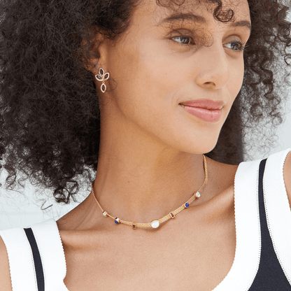 Model wearing the Fleur de Feu garnet drop earrings paired with a matching gold gemstone choker necklace.