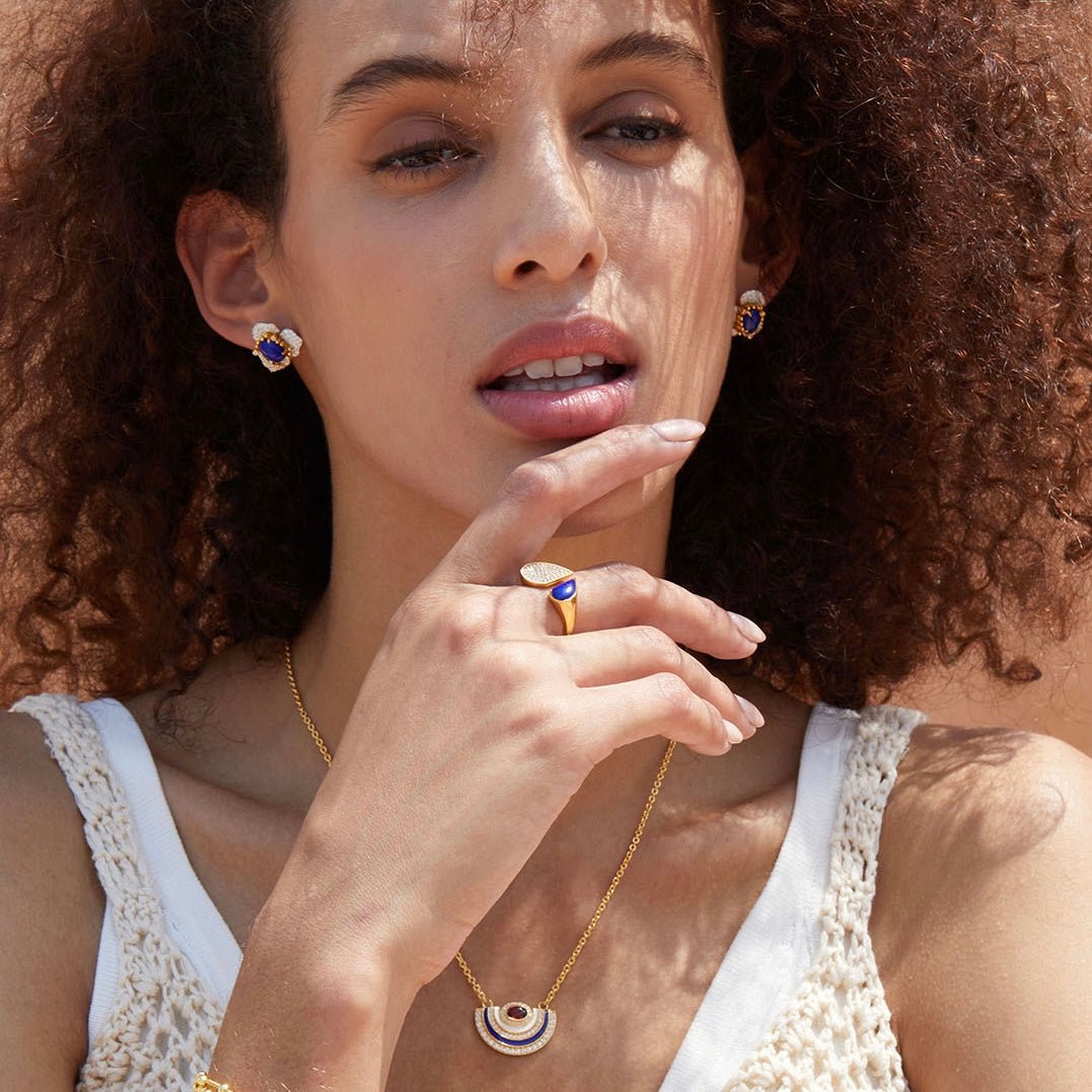 Model wearing the complete Fleur d’Écume jewelry set, including lapis lazuli stud earrings, matching ring, and necklace.