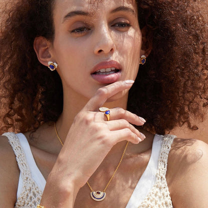 Model wearing the complete Fleur d’Écume jewelry set, including lapis lazuli stud earrings, matching ring, and necklace.