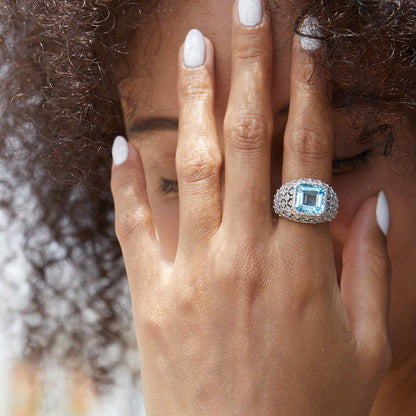 Close-up lifestyle portrait of a model wearing the Awakened Time Glacier Crown Ring featuring a radiant blue topaz center stone set in 18ct white gold vermeil.